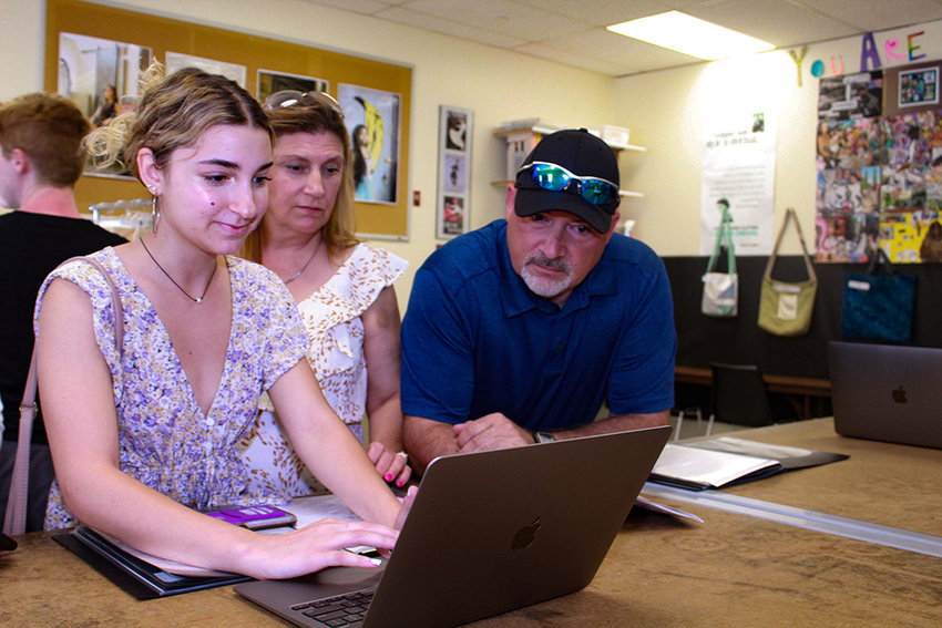 Ulster BOCES Fashion Design &amp; Merchandising graduate Chloe Quattrochi (left), from the Wallkill Central School District, shows her parents, Anthony and Kim Quattrochi, her digital portfolio during the Career &amp; Technical Center&rsquo;s Senior Tribute and Exhibition of Learning.