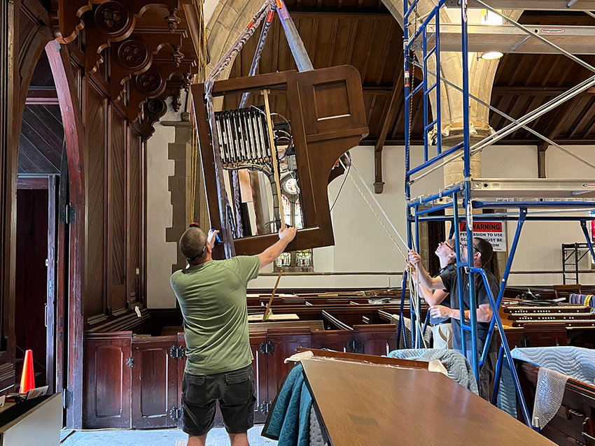 Douglas McKeever helps guide the organ console as it is lifted to the top balcony ready for reinstallation.