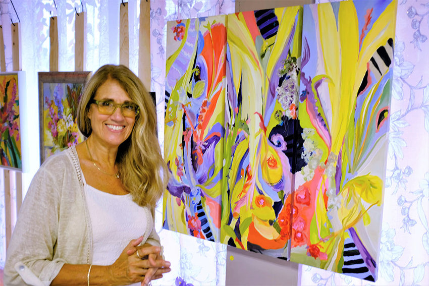 Highland Artist Beth Walters-Storyk stands beside one of her paintings, &lsquo;Magical Garden Triptych&rsquo;