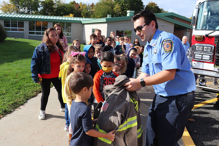A Marlboro Elementary School student feels how heavy a firefighter's jacket is during Fire Prevention Week activities on October 14.