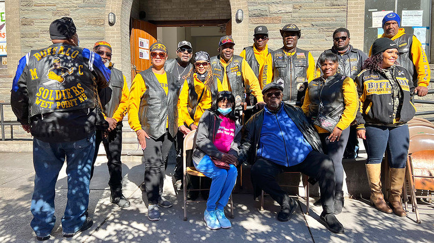 Calvary Pastor J. Edward Lewis [center in blue] joins together with the Buffalo Soldiers to celebrate the fire prevention fair&rsquo;s success and Calvary Church.