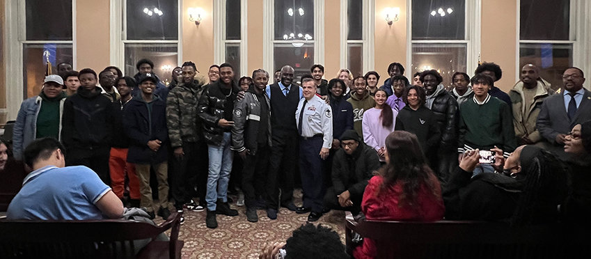 Coach Malcolm Burks [center in blue] is joined by current and former track and field athletes for several photos to commemorate his achievement.