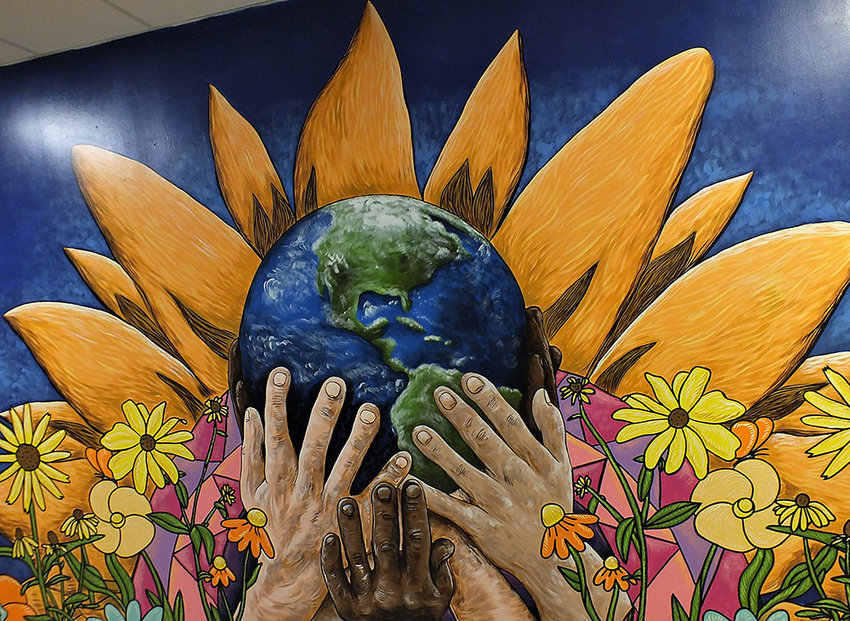 The second mural shows the many hands that support our world.