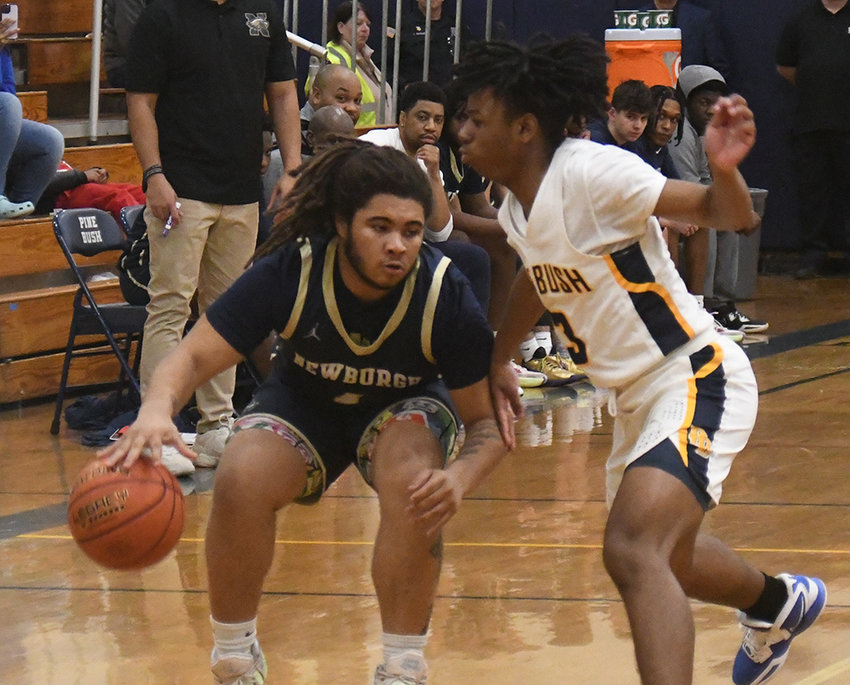 Newburgh's Tajir Walker dribbles the basketball as Pine Bush's Keon Raphael defends during Wednesday's OCIAA crossover boys' basketball game at Pine Bush High School.