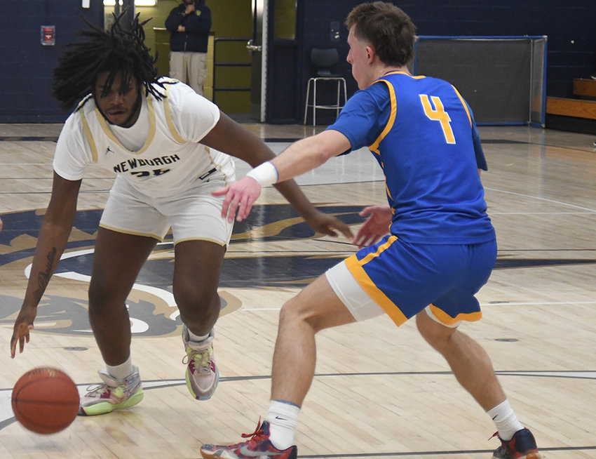Newburgh's Naeshawn Moody drives the basketball as Washingtonville's John Cronin defends during Saturday's Section 9 Class AA quarterfinal boys' basketball game at Newburgh Free Academy Main Campus.