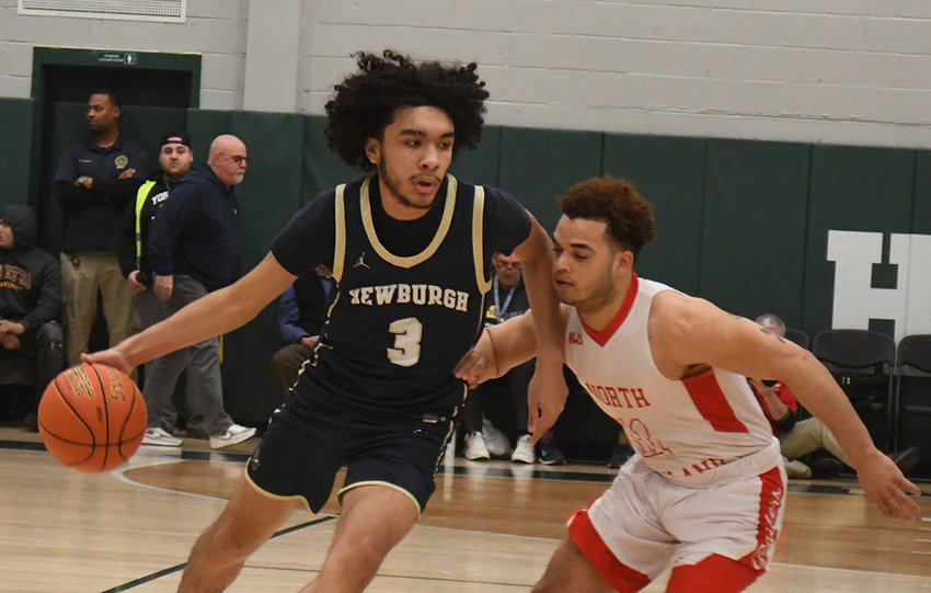 Newburgh's Aiden Brown drives the basketball as North Rockland's Yariel Gomez defends during Saturday's NYSPHSAA Class AA regional final at Yorktown High School.