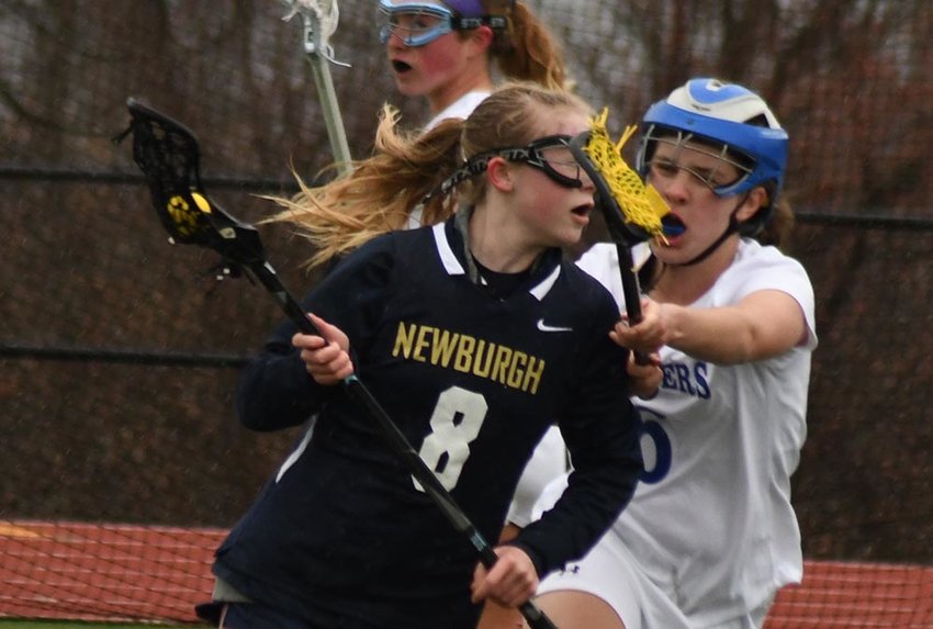 Newburgh's Katie Bell carries the ball as Wallkill's Paige Badner defends during Friday's non-league girls' lacrosse game at Wallkill High School.