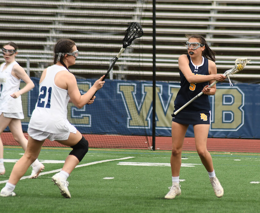 Pine Bush's Mackenzie Brown plays the ball as Newburgh's Madison Foti defends during a girls' lacrosse game on April 11 at Academy Field in Newburgh.