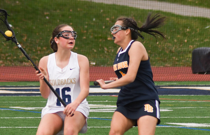 Newburgh's Emily Leonard looks to pass the ball as Pine Bush's Mackenzie Brown defends during a girls' lacrosse game on April 11 at Academy Field in Newburgh.