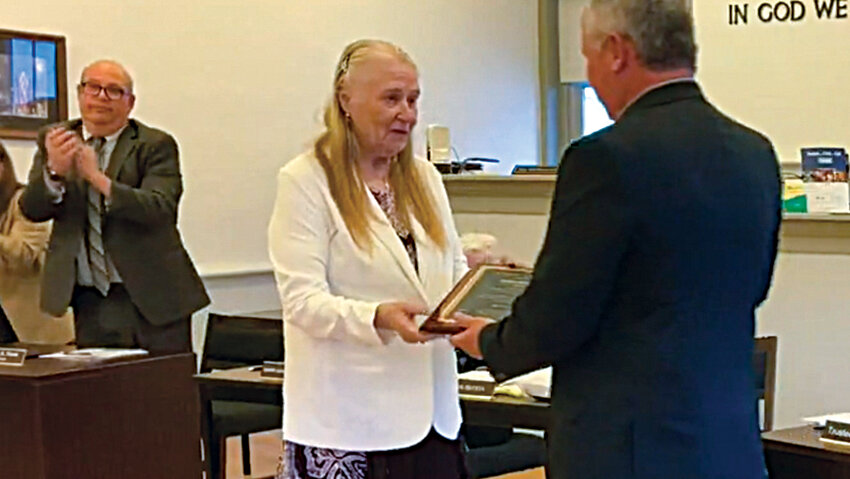 Former Montgomery Village Trustee JoAnn Scheels accepts a plaque from Mayor Steve Brescia at last week&rsquo;s village board meeting.