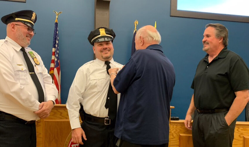 Dennis Barnett is &ldquo;pinned&rdquo; for his promotion to lieutenant by his father, former deputy mayor and former police chief James Barnett, during a recent village board meeting.  Pictured are (l-r) Chief Arnold &ldquo;Butch&rdquo; Amthor, Dennis Barnett, James Barnett and Mayor Dennis Leahy.