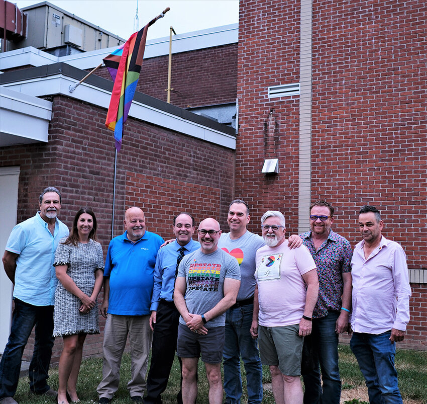 The Marlborough Town Board and members of the LGBTQ+ community pose underneath the Pride Flag that is flown at town hall for the month of June. Pictured (l. &ndash; r.) board members Manny Cauchi, Sherida Sessa, Ed Molinelli, Scott Corcoran, Rob Conlon, Joe Caserto, Tim Lawton, Michael Hall and board member Dave Zambito.