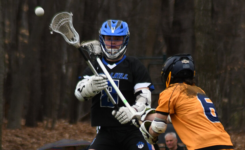 Wallkill&rsquo;s Richie Martinez passes the ball over the defense of Pine Bush&rsquo;s Trevor Zupetz defends during a non-league boys&rsquo; lacrosse game on March 27 at Pine Bush Elementary School.