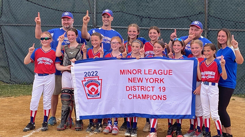 The Montgomery Minors softball team poses with the District 19 flag after posting a 4-2 win over Goshen on July 6, 2022, at Veterans Park in Montgomery. Many of these same players were on the 2023 Majors team that were disqualified from the District 19 tournament after it was ruled to have played two games with two ineligible players.