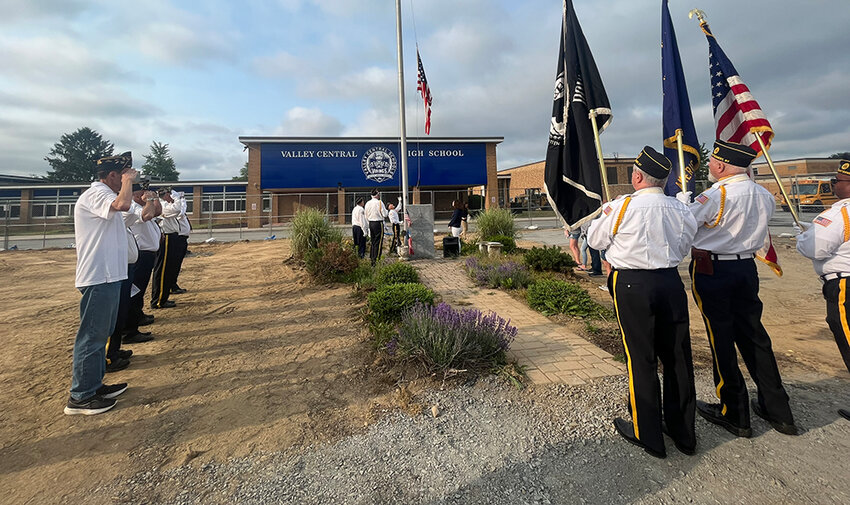 American Legion and VFW members saluting to Taps while the flag is lowered.