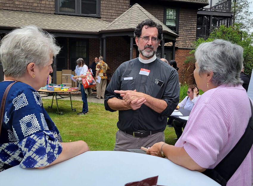 The Rev. Richard Witt, Executive Director of Rural &amp; Migrant Ministry, Inc., [center] speaks with attendees at the  event at RMM&rsquo;s Grail campus in Cornwall-on-Hudson.