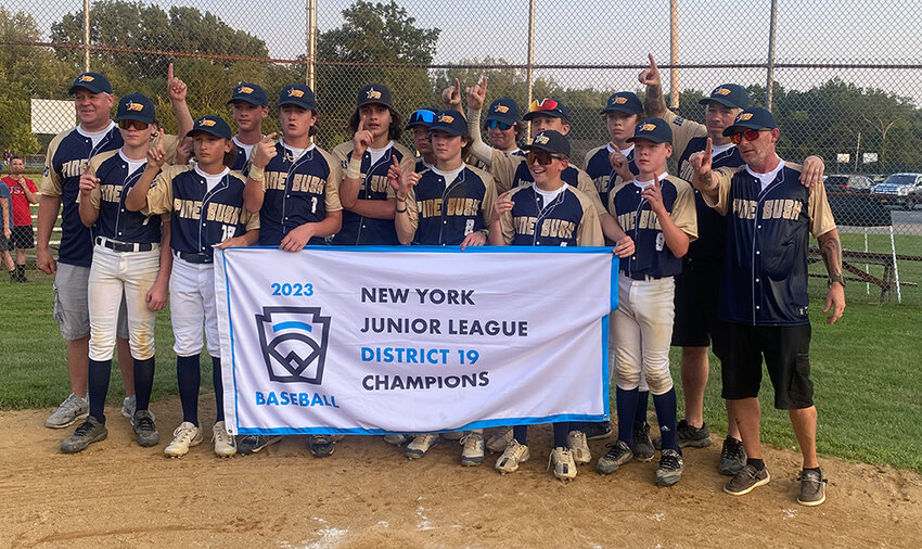 Pine Bush poses with the District 19 Junior baseball flag after beating Monroe-Woodbury, 3-2, on July 11 at Crawford Town Park in Pine Bush.