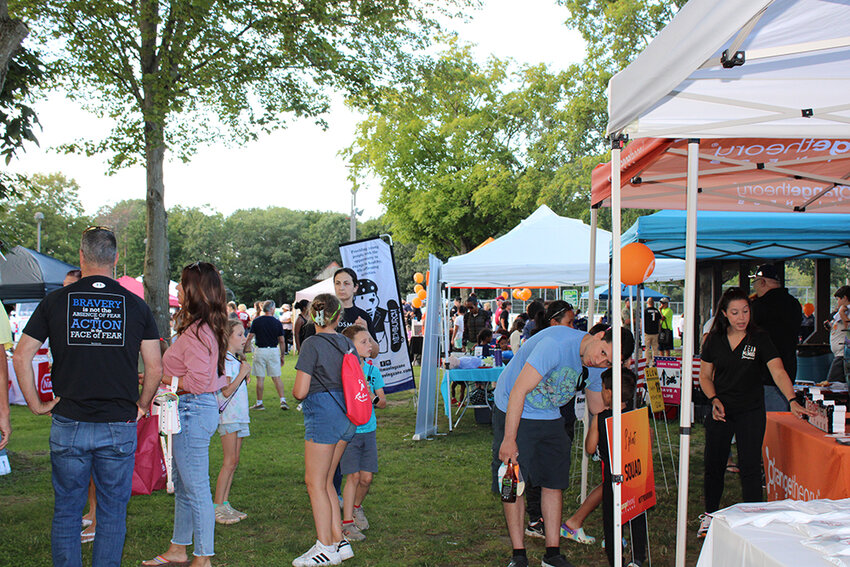 Families walk amongst the vendor booths at Chadwick Lake Park.