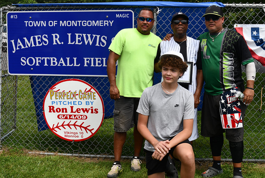 Ron Lewis, back center, poses in front of the sign designating the Berea Field the James Ronald Lewis, Sr., Softball Field, with his sons, Justin, left, and Ron Jr. His grandson, Deven Lewis, is in front.