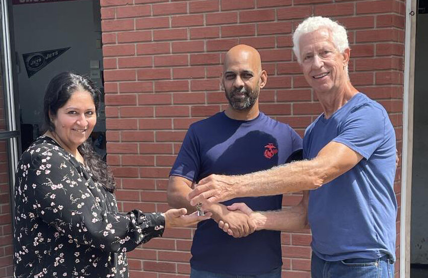 Larry Kraus with the auto center&rsquo;s new owners, Husnain and Saba Hussain.