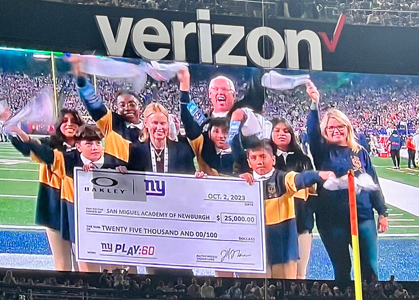 San Miguel Academy rowers on the jumbotron at Metlife Stadium accepting a check from the Giants Organization and the NFL.