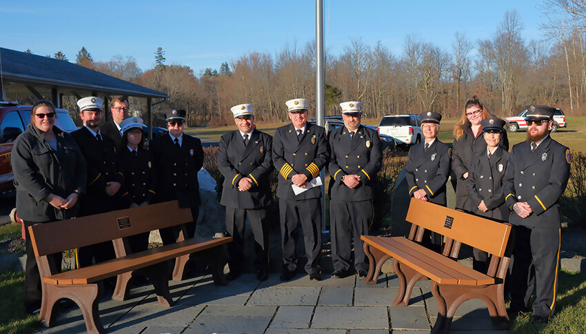 Clintondale Fire Chief Rick Brooks [center] stands with members of his department beside the memorial benches to honor the late Shirley Anson and Preston ‘Mickey’ Palazzo. Pictured L-R Caitlin Shoureck, Zack Adolphsen, Darren Menkins, Sherri Mackey, Deana Mackey-Leon, Phil Sabarese, Asst. Chief, Rick Brooks, Chief, Jeremy Nash, Asst. Chief, Patti Brooks, Meghan Shoureck, Melissia Leon, Billy Mackey.
