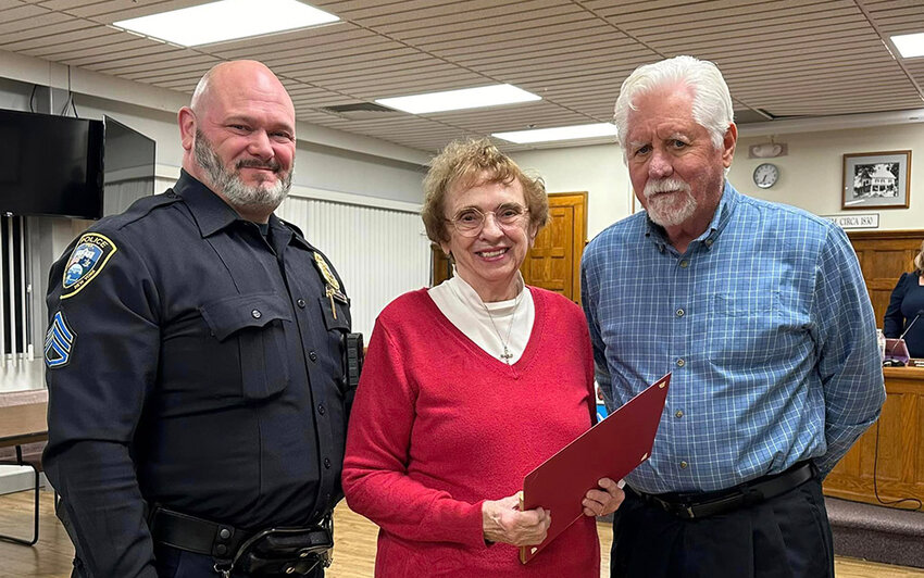 Gail VanTassel (middle) standing with Town Supervisor Ronald Feller (right) and Gail&rsquo;s son, Sergeant John VanTassel (left).