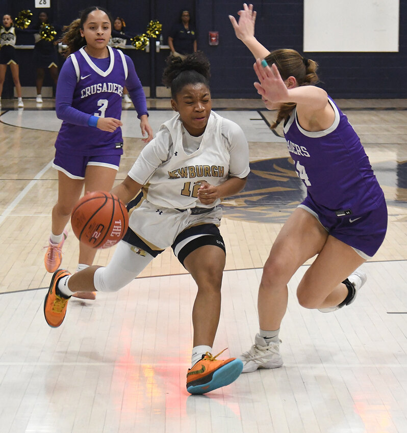Newburgh’s T.T. Burden drives toward the basket as Monroe-Woodbury’s Sienna Feeley defends and Madison Fileen (3) trails the play during Friday’s OCIAA Division I girls’ basketball game at Newburgh Free Academy.