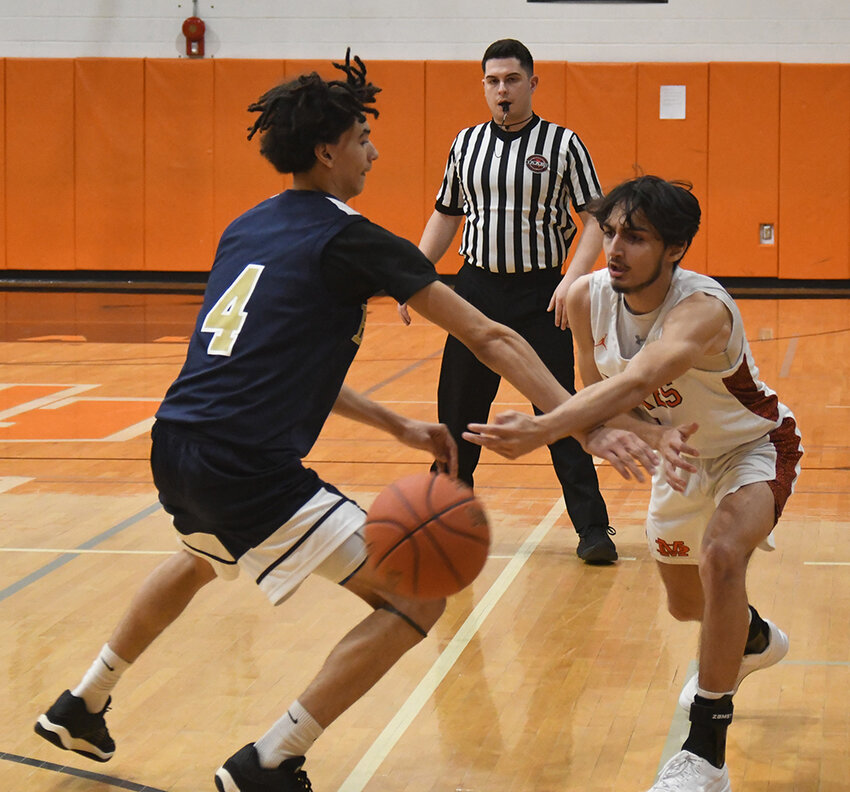 Marlboro’s Miles Brooks passes the ball around Beacon’s Marciano Rodriguez during a non-league boys’ basketball game on Feb. 6 at Marlboro High School.