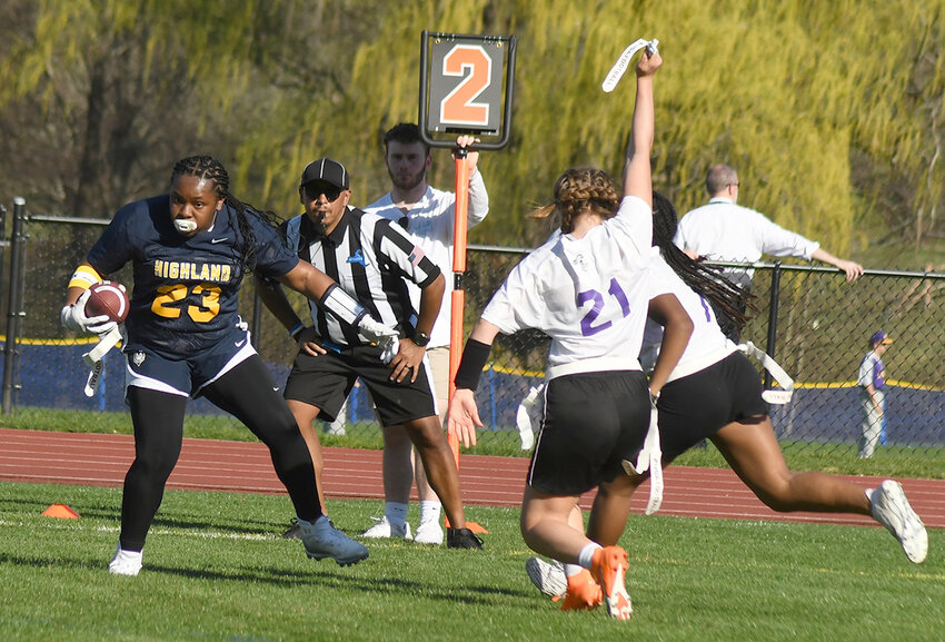 Highland’s Aaliyah Ghafoor runs the football as a Monroe-Woodbury player grabs the flag during a flag football game on April 13, 2023, at Highland High School.