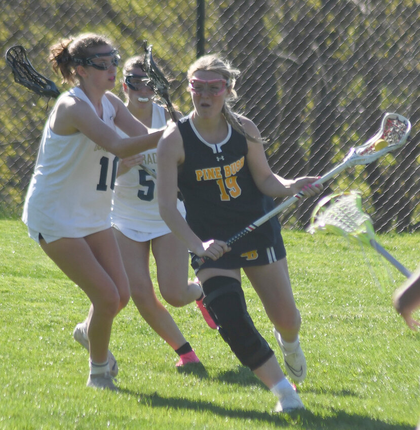 Pine Bush&rsquo;s Sophia Licardi carries the ball as Newburgh&rsquo;s Vivian Gage and Gianna Alisandrella (5) defend during a Division I girls&rsquo; lacrosse game on April 16 at Newburgh Free Academy North.