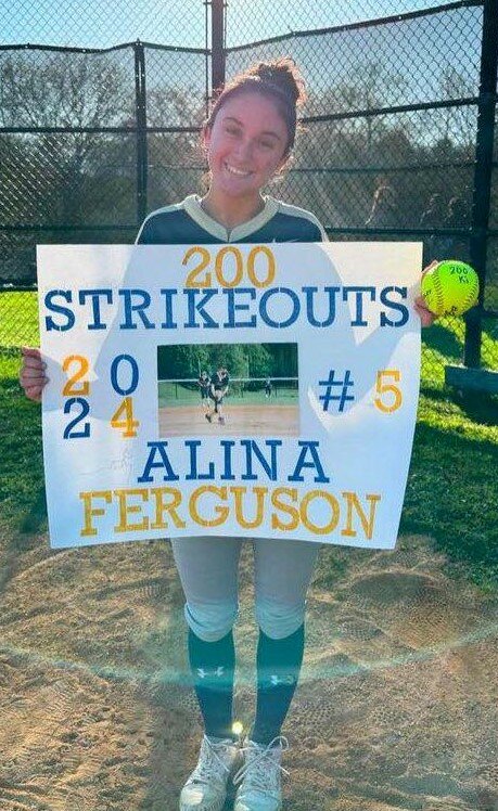 Newburgh’s Alina Ferguson is shown with a sign and the ball she recorded her 200th strikeout with on April 22 at Newburgh Free Academy’s North campus.