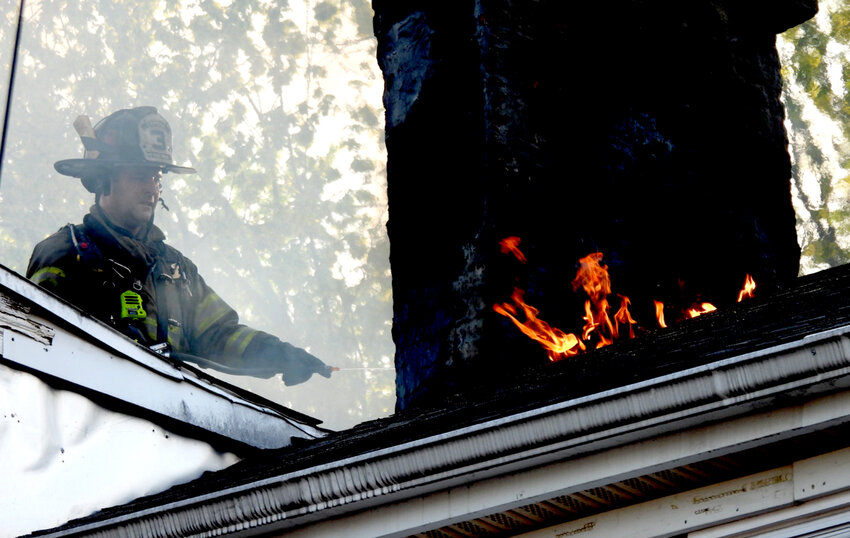 A firefighter on the roof at 24 City Terrace, early Saturday morning