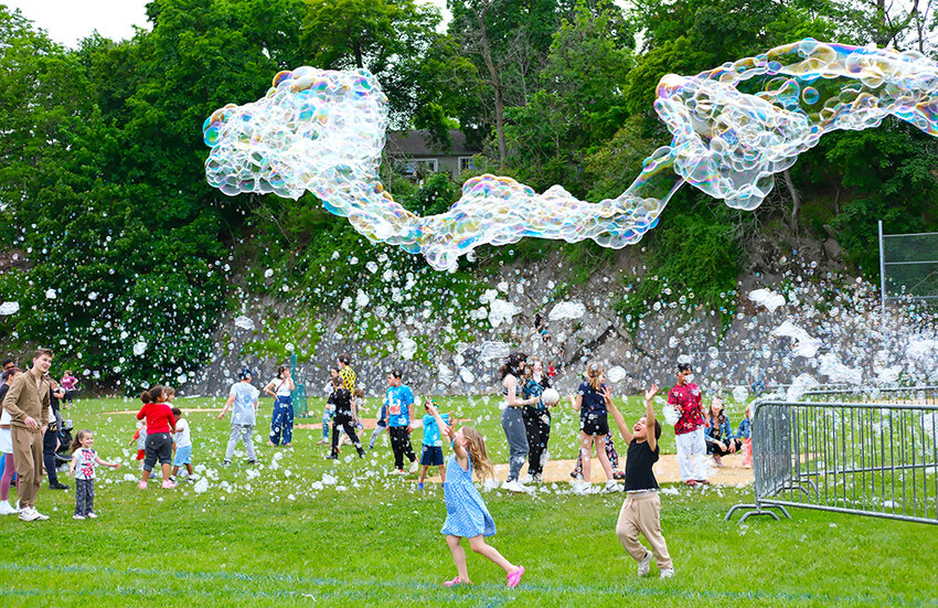 As most kids were being covered in a blizzard of bubbles, two were trying hard to reach a dragon shaped figure floating high above them at last Saturday’s Spring Fest