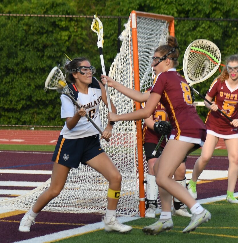 Highland’s Leah Klotz brings the ball around the cage as James I. O’Neill’s C.J. Conkey defends during the Section 9 Class D championship girls’ lacrosse game on May 22 at James I. O’Neill High School in Highland Falls.