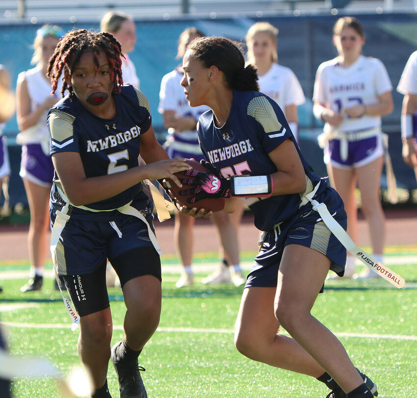 Newburgh quarterback Kallie McCoy hands the ball off to Saraji Good during a flag football game at Academy Field in Newburgh.