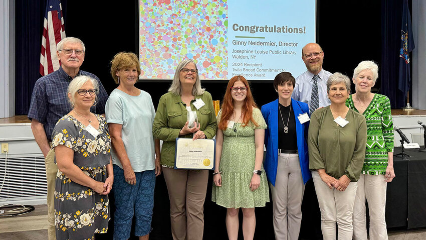 Ginny Neidermier holding up the Twila Sneed Award with members of the SENY Library Resources Council. From left to right: Frank Appell, Beth Balogh, Jean Crawford, Neidermier, Jada Wessenberg, Alyssa Masotto, Mel Wesenberg, Mary Boylan, and Mary Walton.