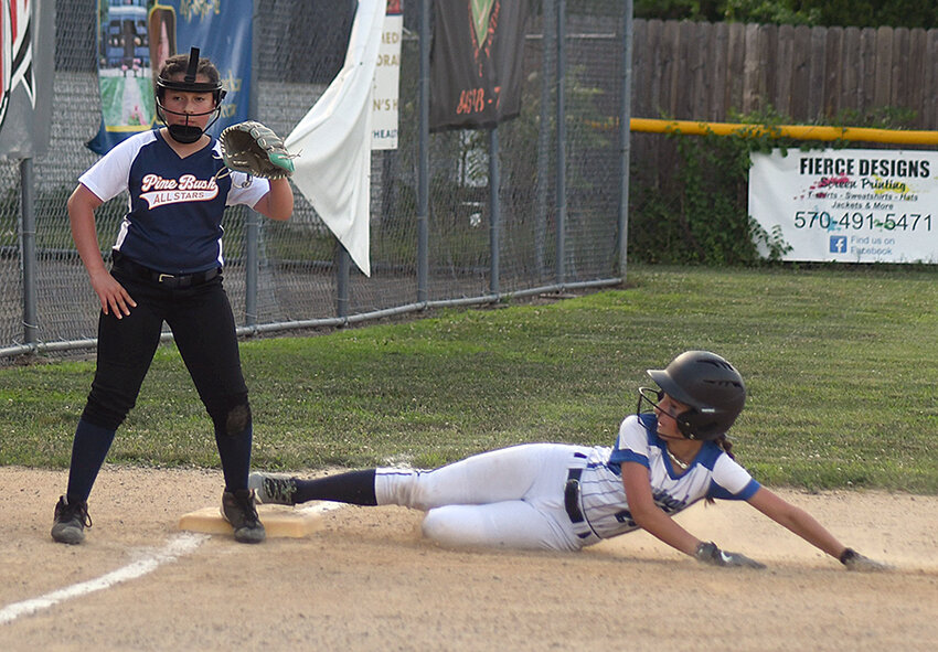 Town of Newburgh’s Mattingly Riglioni slides into third base as Pine Bush third baseman Adrianna Gonzalez covers the base during Wednesday’s District 19 Minors softball game at Port Jervis Little League.