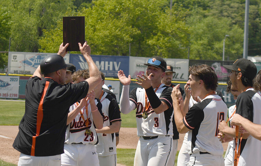 Marlboro coach John Morrissey holds up the Section 9 Class A championship baseball plaque last month at Cantine Field in Saugerties.
