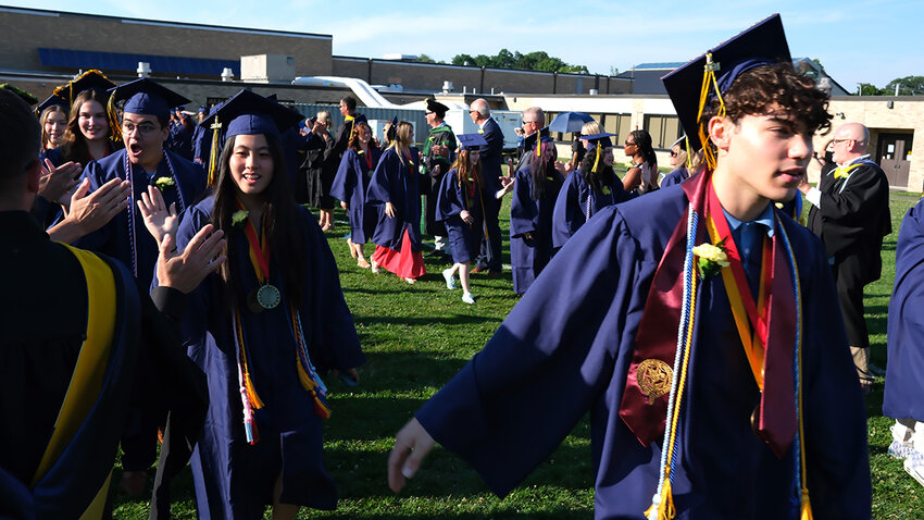 The Highland High School Class of 2024 hi-fives their teachers, the Board of Education and administrators as they processed out onto the field for their graduation ceremony.