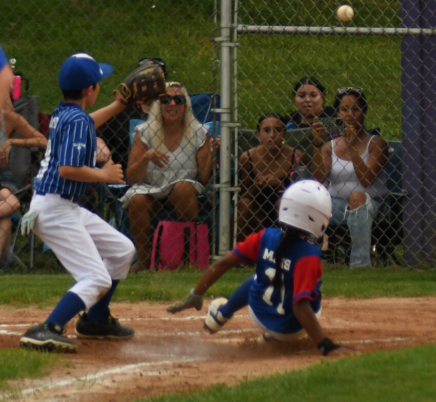 Middletown’s Hayden Mays slides into home plate as Montgomery pitcher Wesley Lloyd waits for the throw as he covers home plate during Friday’s District 19 Minors baseball game at Warwick Little League.