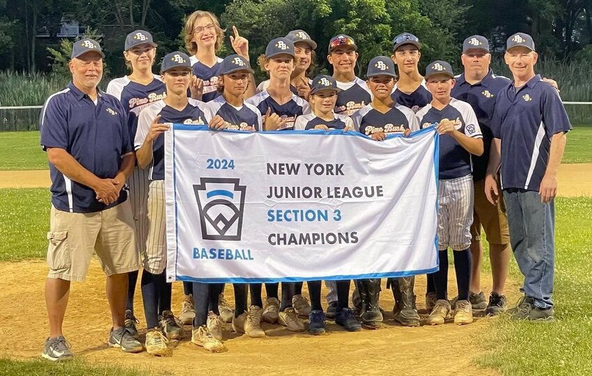 The Pine Bush  junior baseball team poses with the Section 3 North championship flag after beating Harrison on July 8 at Pine Bush Town Park.