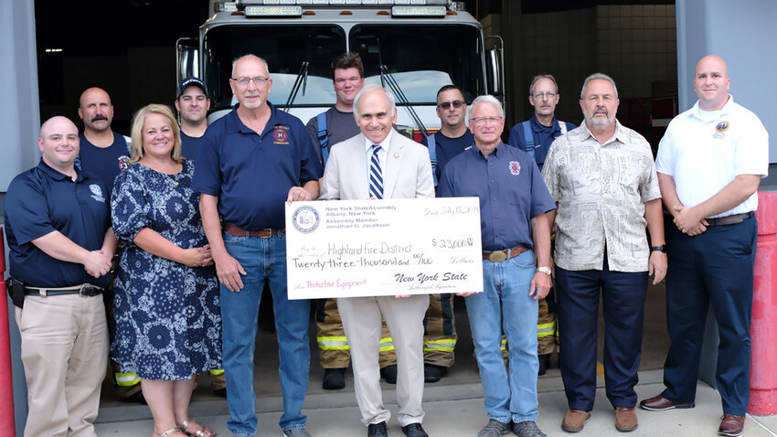 Assemblyman Jonathan Jacobson presents a check for $23,000 to the Highland Hose Company. Pictured L-R: Michael Gaffney, Deputy Director-Ulster County Dept of Emergency Services; Mike Schaeffer, Gina Hansut , Ulster County Legislature; Nathan Peura, Alan Barone, Fire Commissioner, Nicholas Rosenkranse, Assemblyman Jonathan Jacobson, George Monteverdi, Peter D. Miller, Chief, Roger LaForge, David Plavchak, Town of Lloyd Supervisor; and Everett Erichsen, Director-Ulster County Dept of Emergency Services.