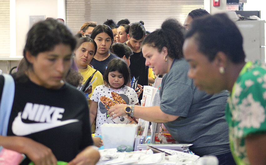 Families make their way to several tables with community resources.