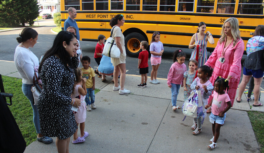 Fort Montgomery Elementary School Principal Jacqueline Rodriguez, left, is shown greeting 2024-25 pre-kindergarten students as they got off the bus at the Highland Falls Intermediate School last Tuesday. The young students, who will attend the HFIS this year while the FMES is under construction, were taking part in a bus orientation/meet the teacher event. With the youngsters at right is PreK Teacher Alli Lennon.