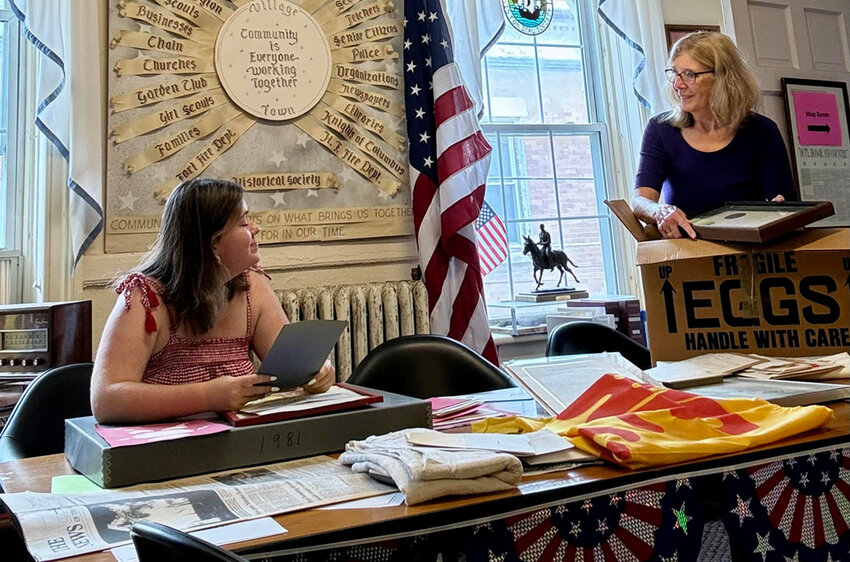 Grace Suchanyc and Historian Ronnie Coffey are shown preparing the soon-to-be Hometown USA exhibit in the Historian’s office this summer.