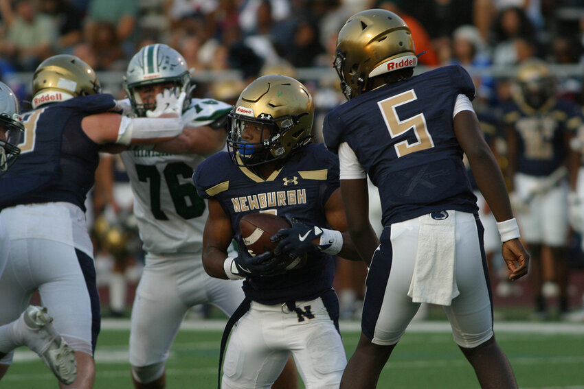 Newburgh’s Bruce Montgomery takes a hand off from Quarterback Jaiseon Barnwell in the first quarter of Friday’s game against Minisink Valley.