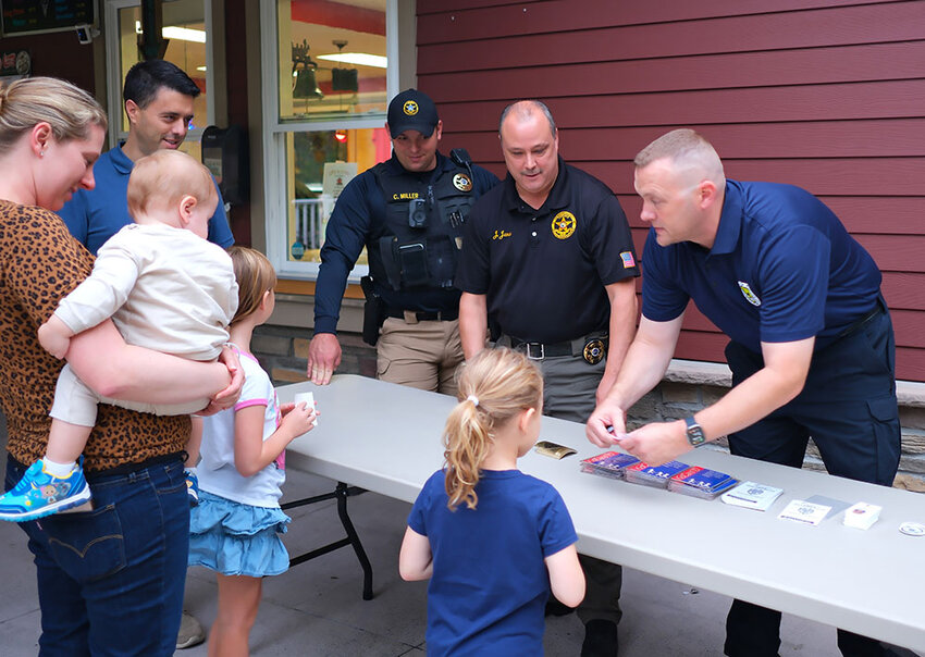 Members of the Lloyd Police Department hand out free ice cream cone tickets and free children ID kits to the parents. Pictured L-R Sgt. Chris Miller, Chief James Janso and Lt. Phil Roloson.