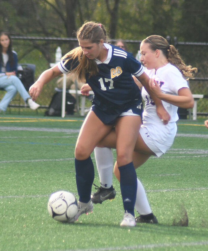 Pine Bush’s Audra Meberg plays the ball as Newburgh’s Addisyn Marrero defends during Friday’s OCIAA Division I girls’ soccer game at Alumni Field at Pine Bush High School.