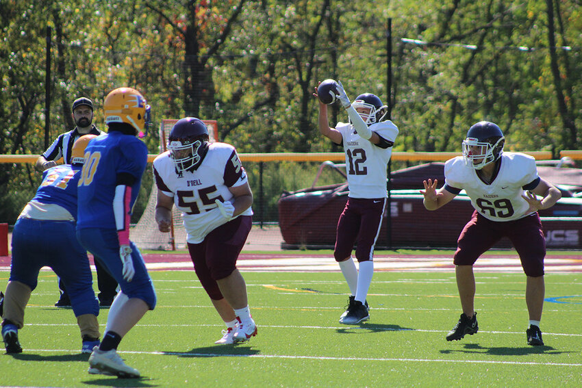 O’Neill quarterback Isaac Post (12) catches the snap as Angel Pratt (55) and Chase DeTemple (69) prepare to block for him.